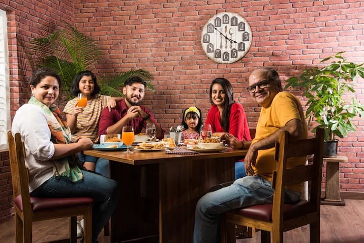 indian-family-eating-food-dining-table-home-restaurant-having-meal-together_466689-11702 (1)